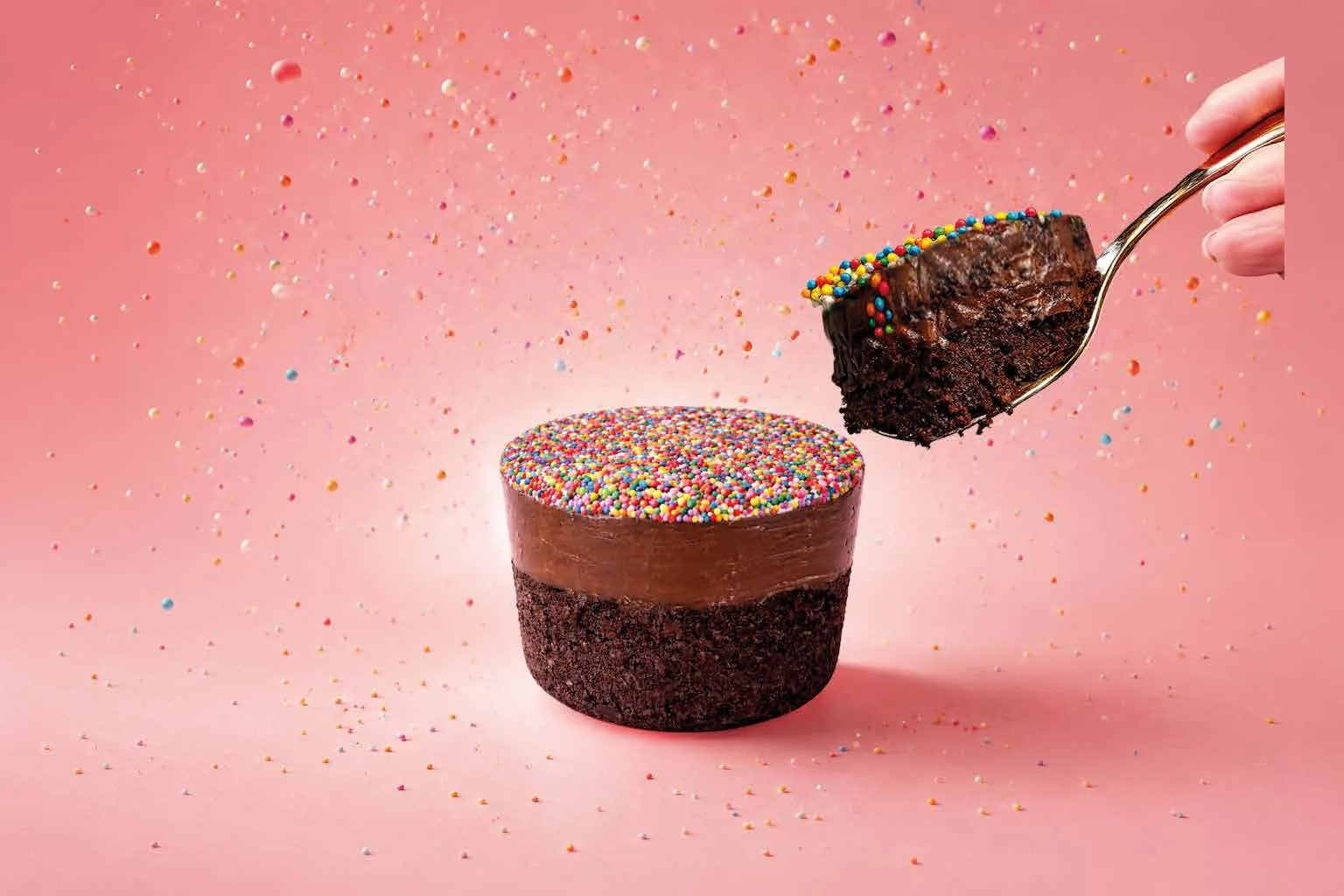 Dot Cake Chocolate cut open – spoon with sprinkles, chocolate cream and dark sponge